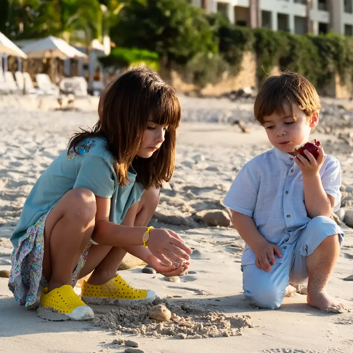 Two young children playing with sand during a family session in Puerto Vallarta