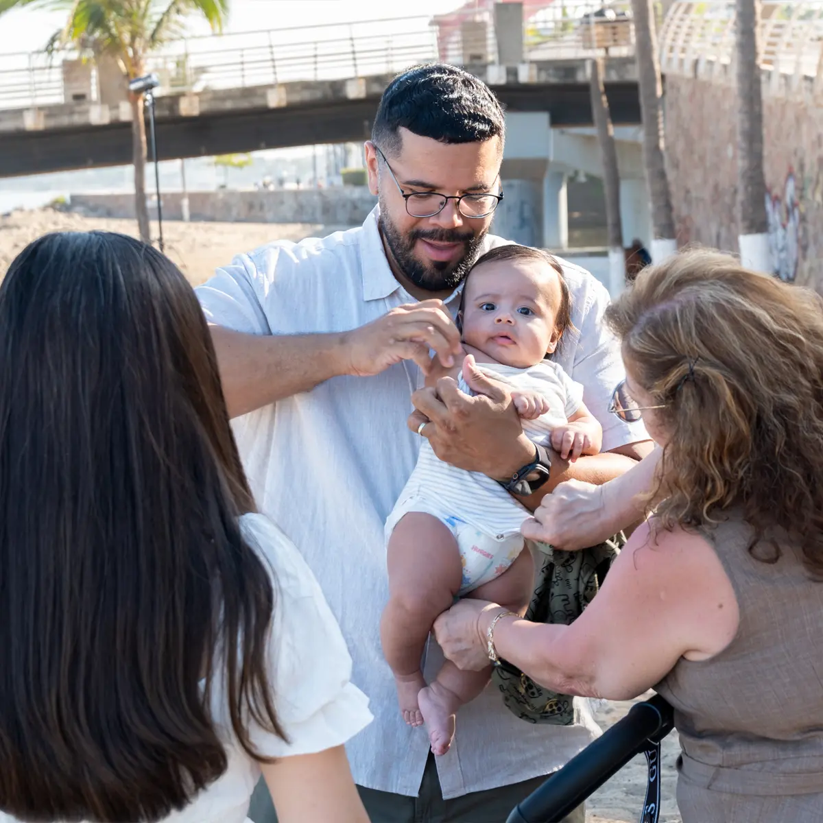 Family gathered around a baby during a session near the Puerto Vallarta waterfront