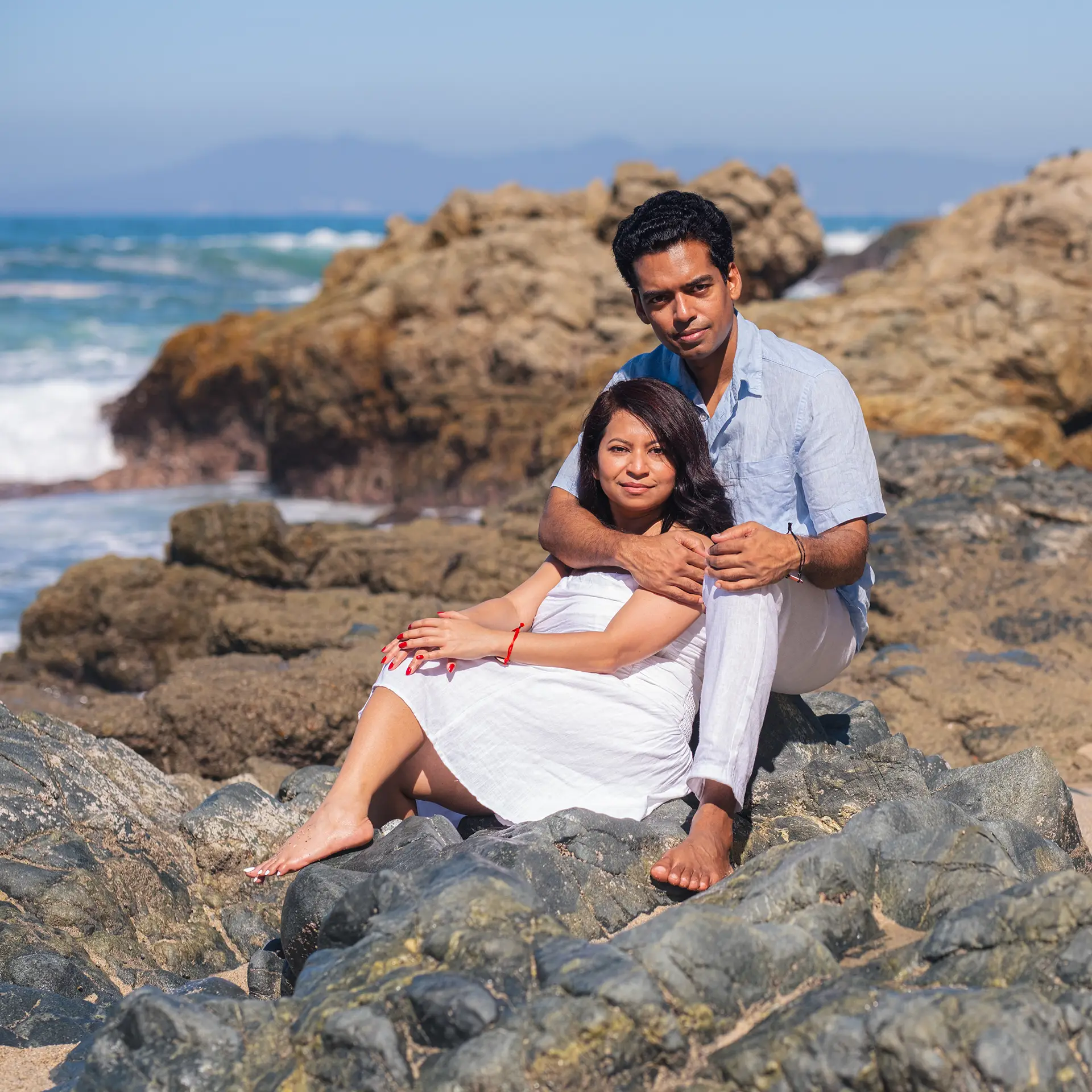 Couple sitting together on the rocks above the Pacific in Puerto Vallarta