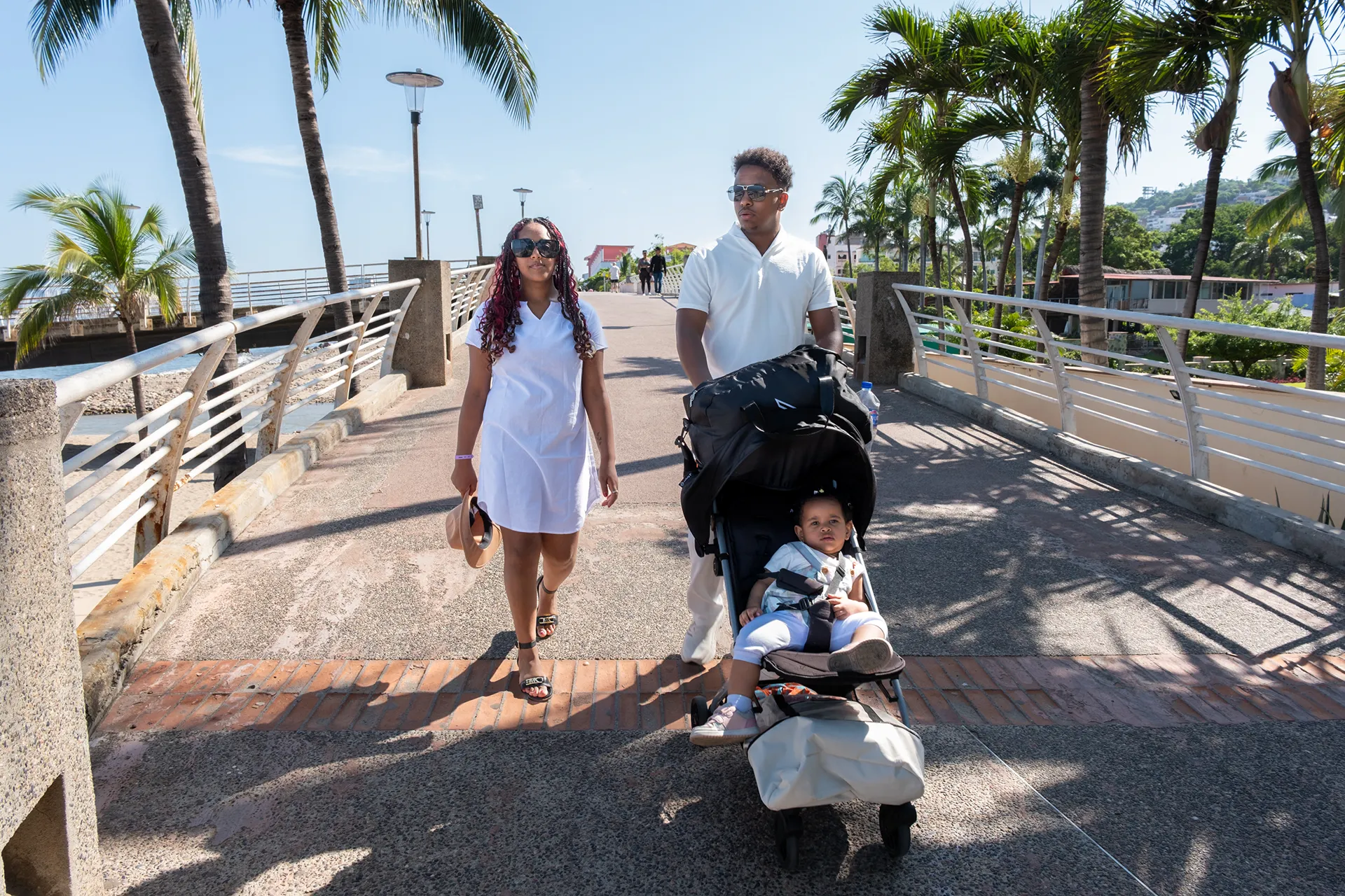 Parents walking with their baby in a stroller along the Malecón boardwalk in Puerto Vallarta