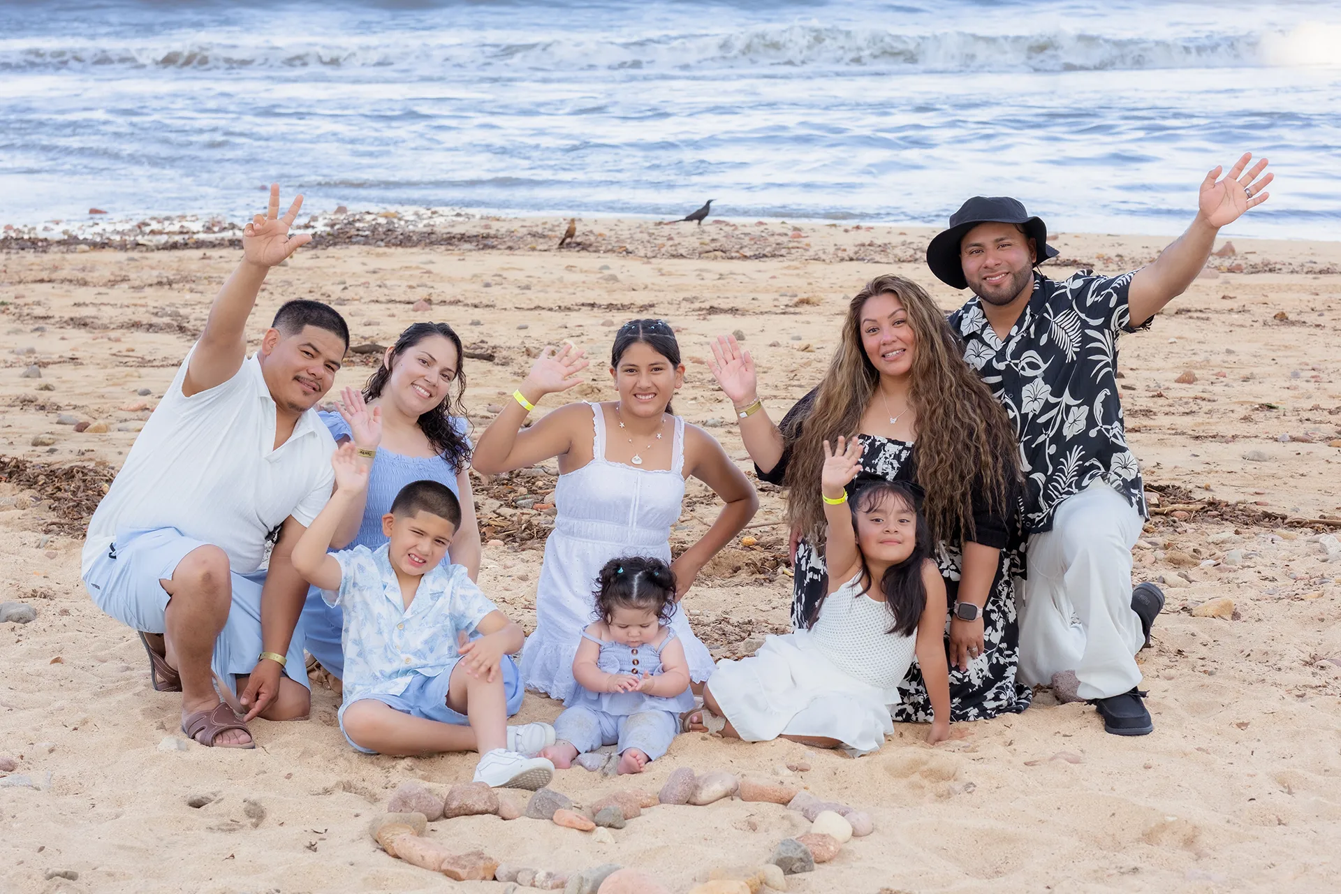 Large family group waving together on the sand during a family reunion session in Playa del Holi, Puerto Vallarta