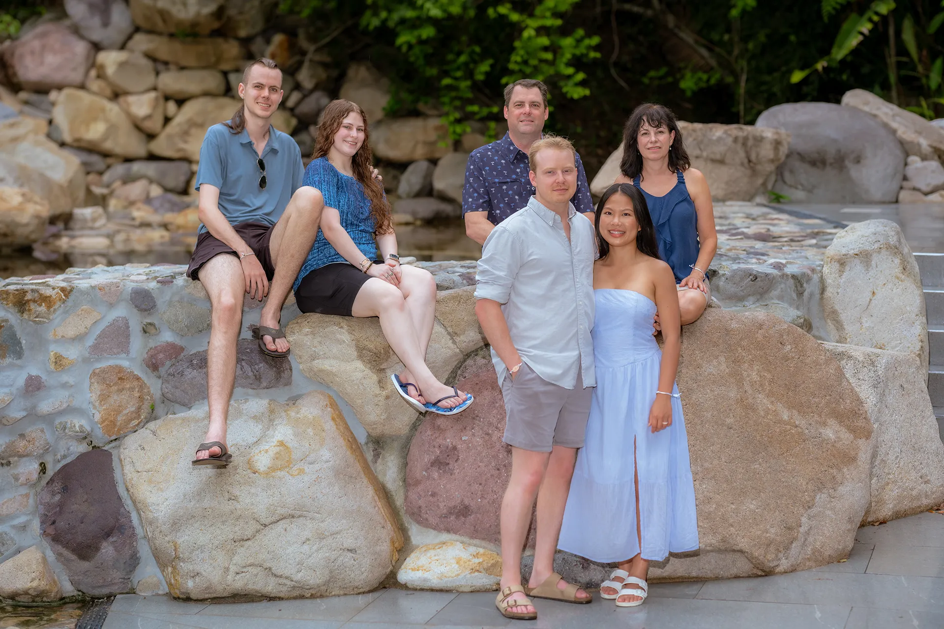 Extended family gathered on the rocks in coordinated blue outfits in Garza Blanca, Puerto Vallarta