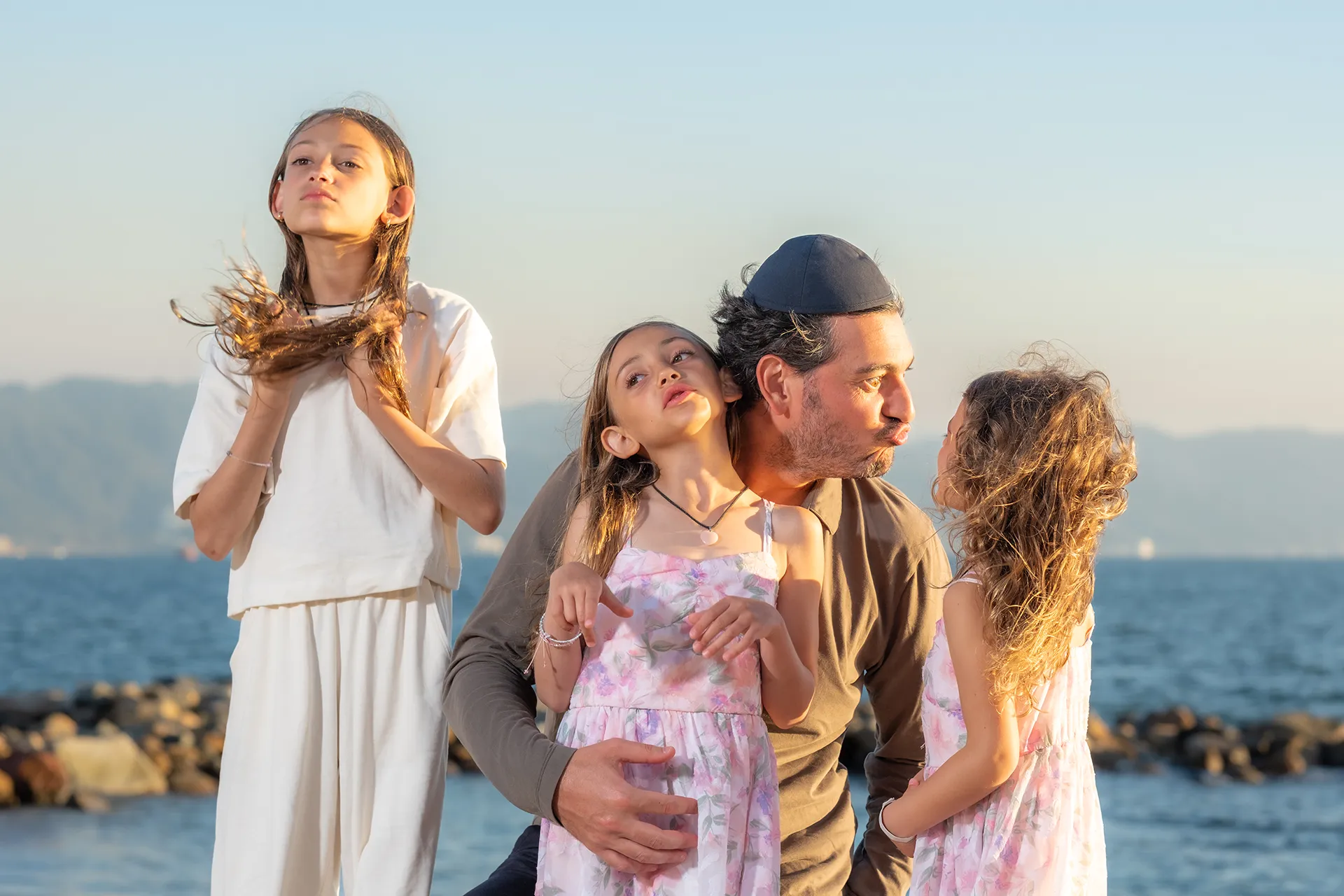 Father with his three daughters at golden hour on a Puerto Vallarta beach