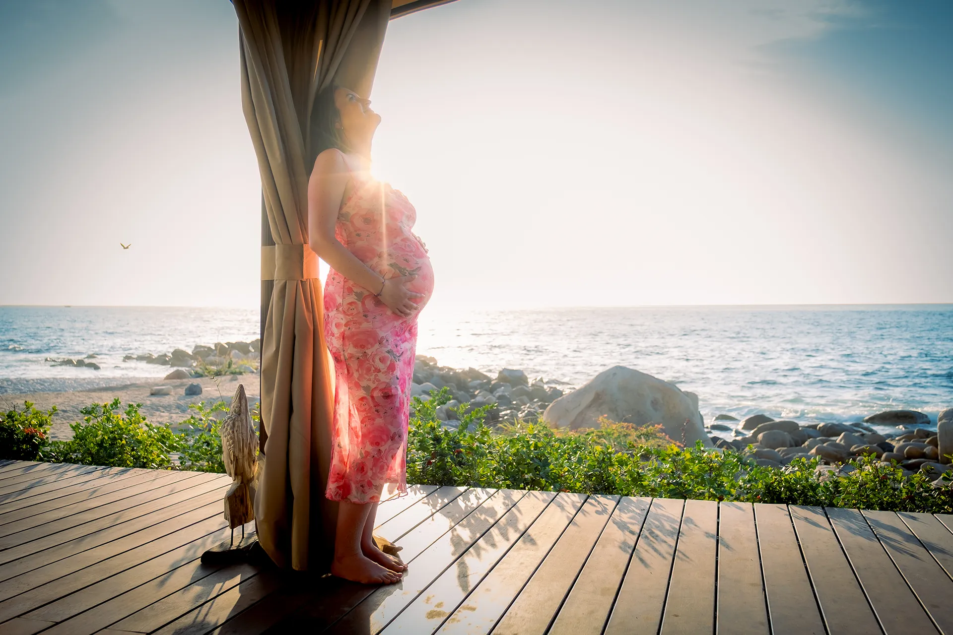 Silhouette of an expecting mother against the Pacific at sunset in Puerto Vallarta